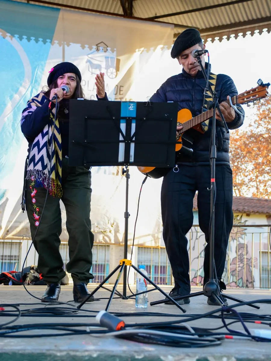 Lina y Eduardo cantando en el escenario de una plaza en una tarde de invierno