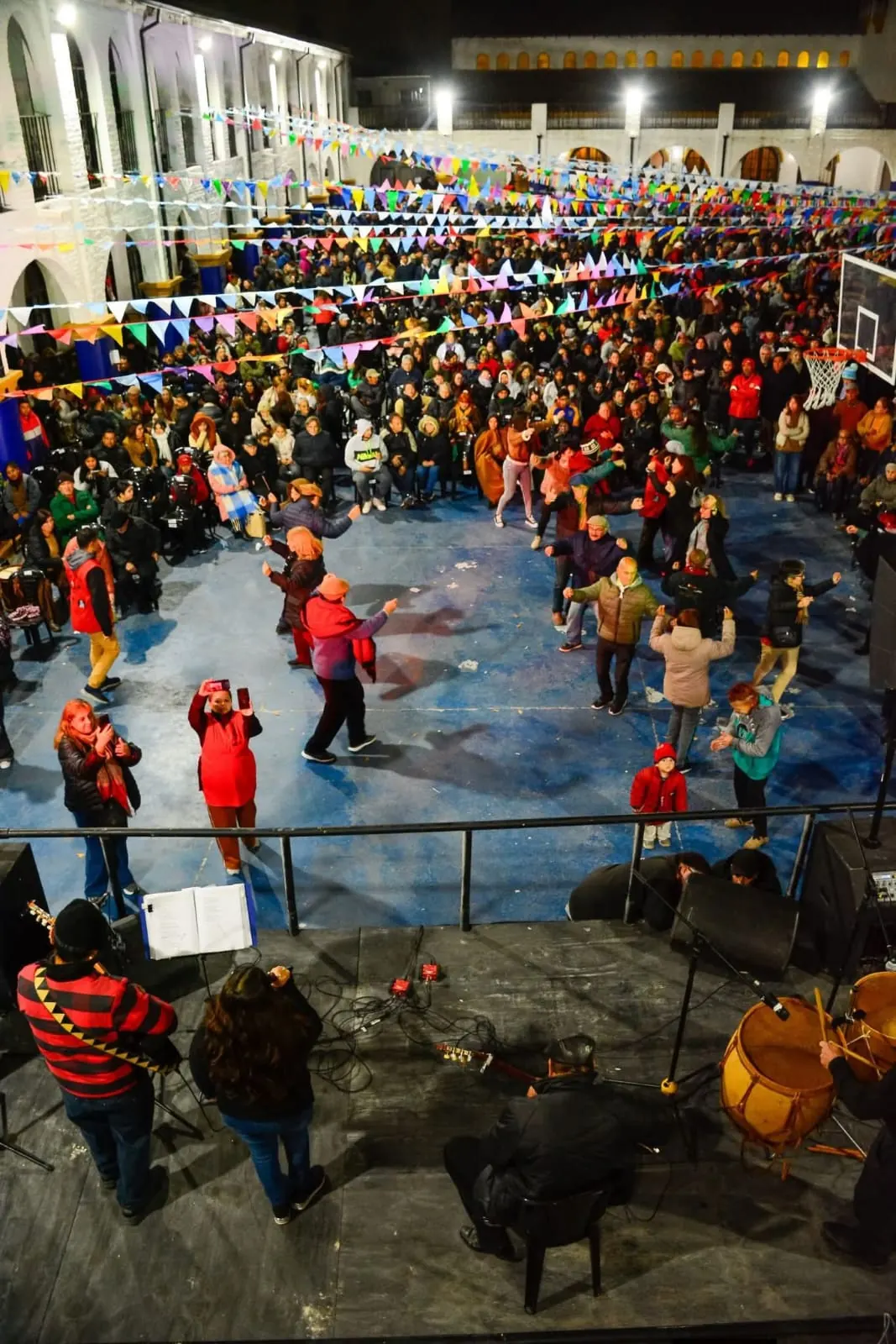 Más de cien personas bailando folklore de noche, vistas desde el escenario del dúo